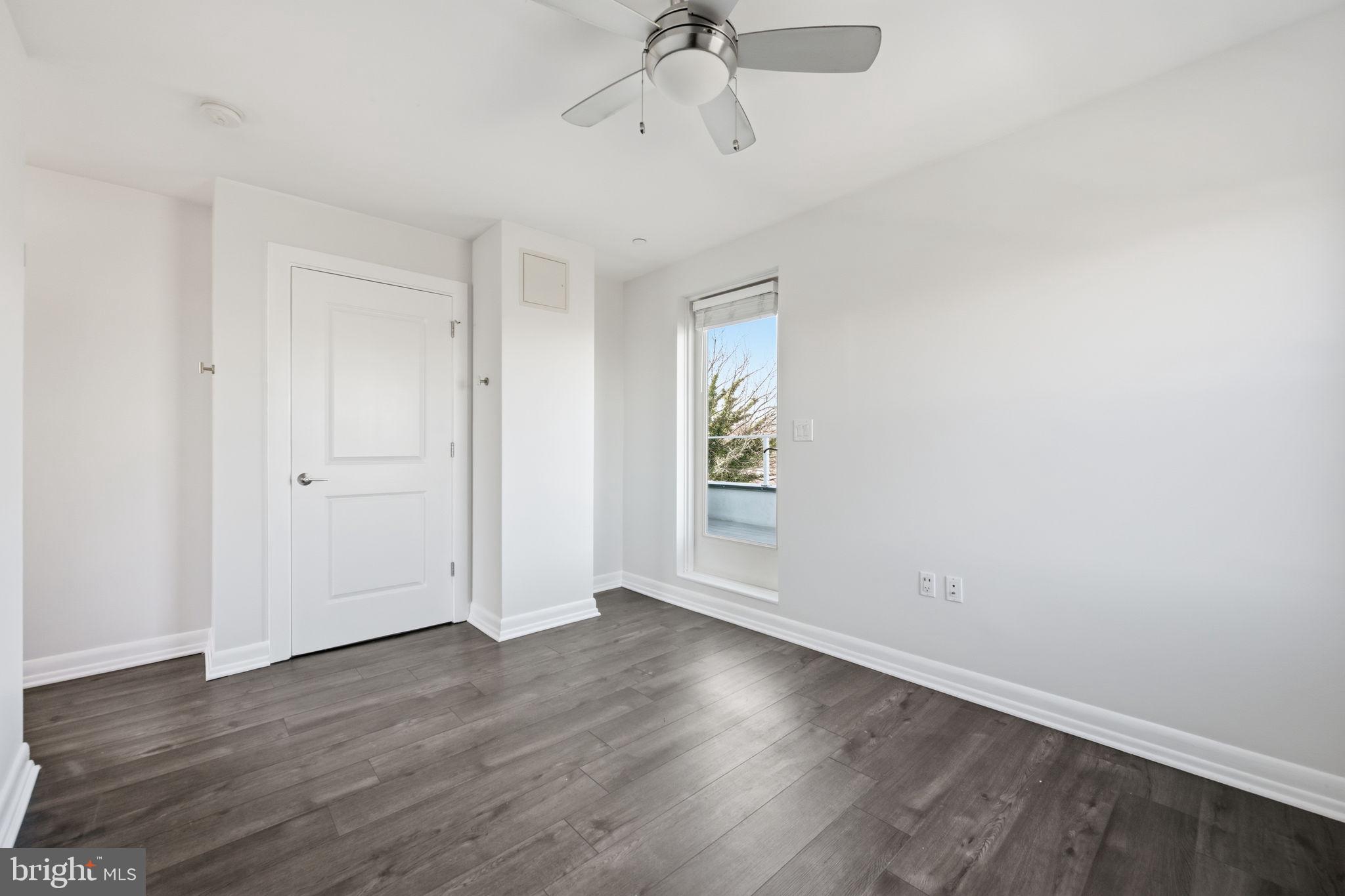 401 15th Street Southeast, Unit 401 Washington, DC 20003 - Photo 15 of 20 an empty room with wooden floor ceiling fan and windows
