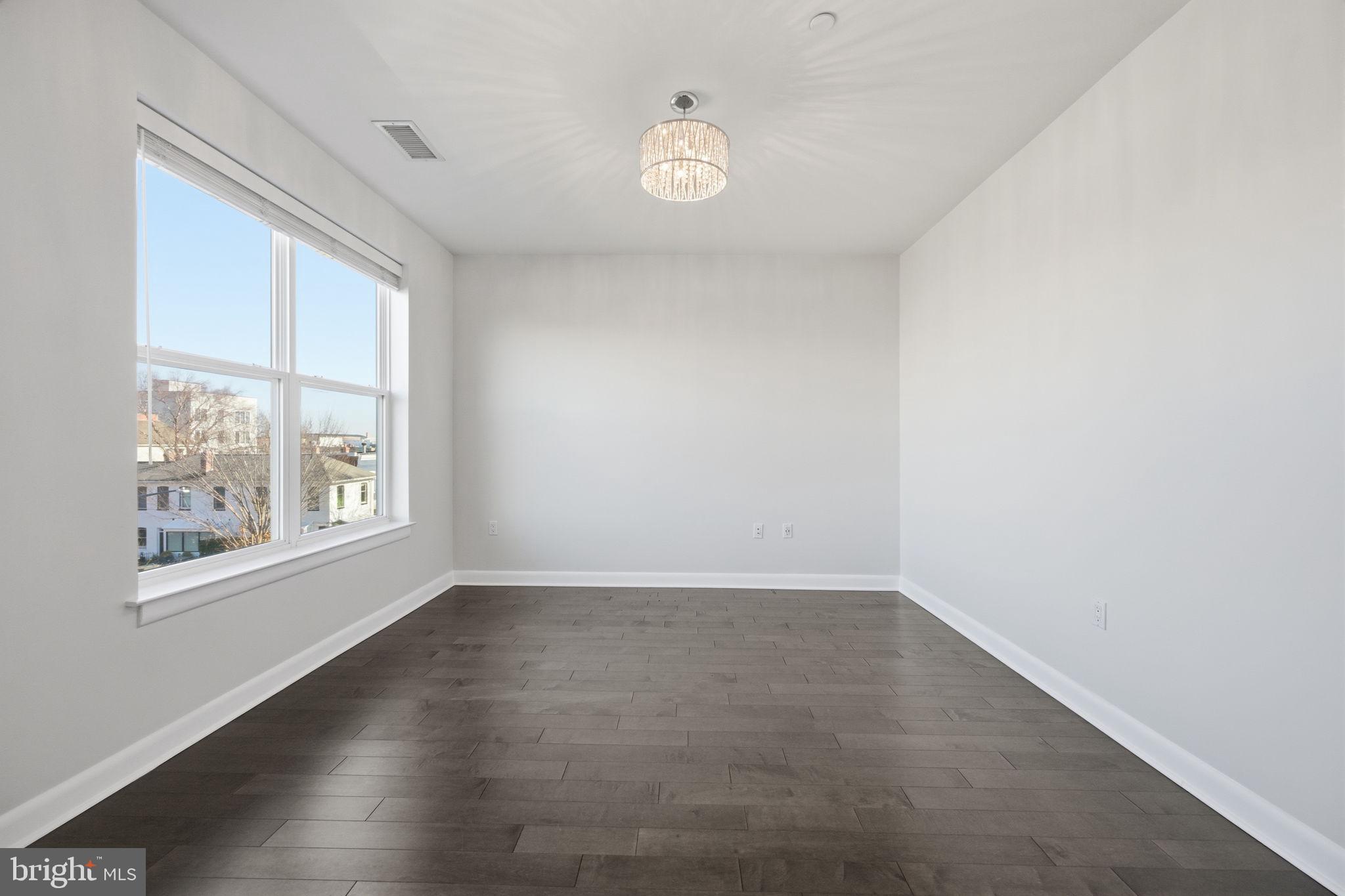 401 15th Street Southeast, Unit 401 Washington, DC 20003 - Photo 7 of 20 an empty room with wooden floor and windows