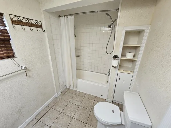 a bathroom with a granite countertop shower and a toilet
