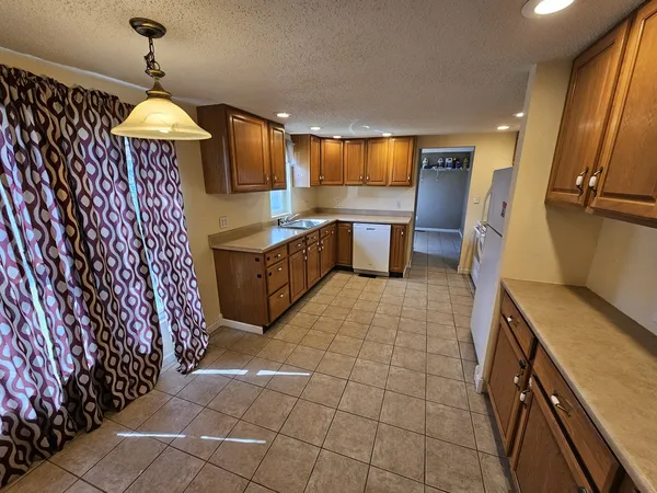 a view of a kitchen with fridge and wooden floor
