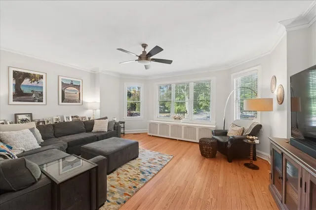 a living room with furniture flat screen tv and a large window