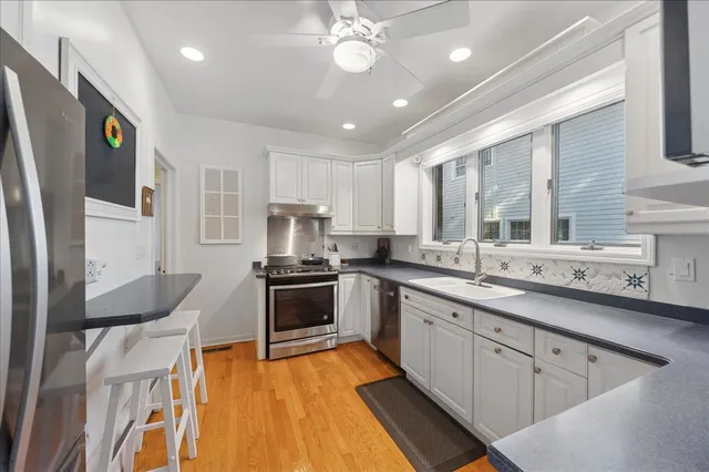 a kitchen with stainless steel appliances a sink stove and refrigerator