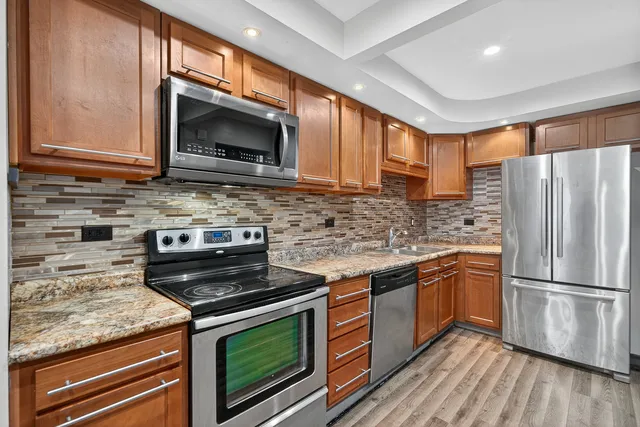 a kitchen with stainless steel appliances granite countertop a stove microwave and refrigerator