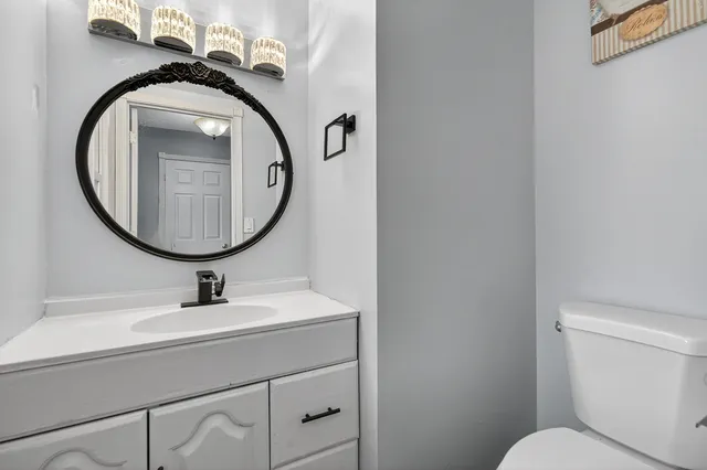 a bathroom with a toilet a sink and a mirror