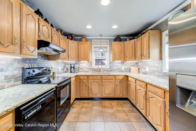 a kitchen with stainless steel appliances granite countertop a sink and a stove