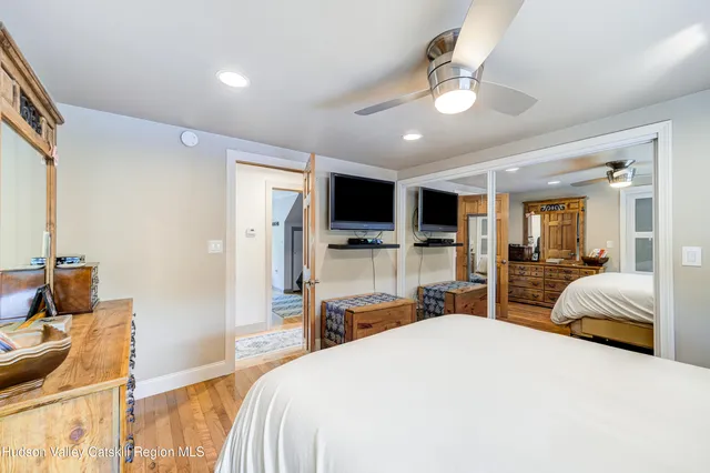 a bedroom with a bed and a large mirror with a flat tv screen