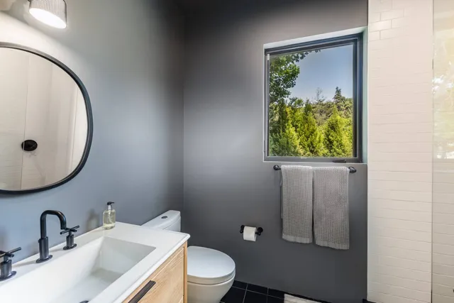 a bathroom with a toilet sink and mirror