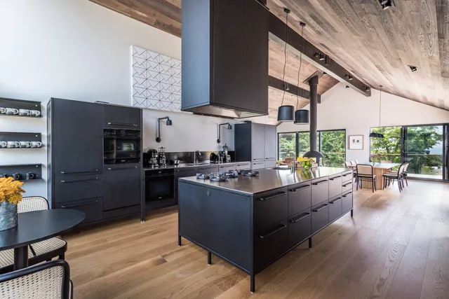 a kitchen with stainless steel appliances granite countertop a lot of counter space and wooden floors