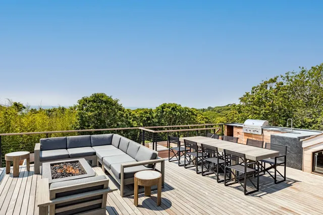 a view of a roof deck with couches and wooden floor