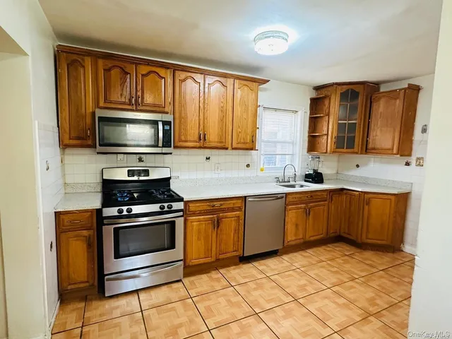 a kitchen with granite countertop a stove top oven microwave and cabinets