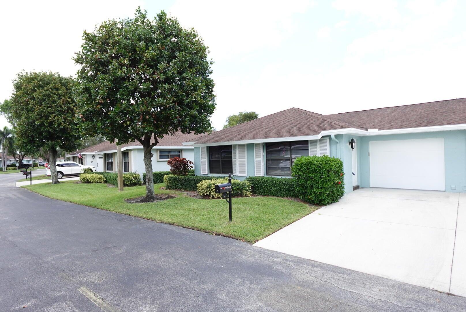 9740 Pecan Tree Drive, Unit A Boynton Beach, FL 33436 - Photo 1 of 5 a front view of a house with a yard and garage
