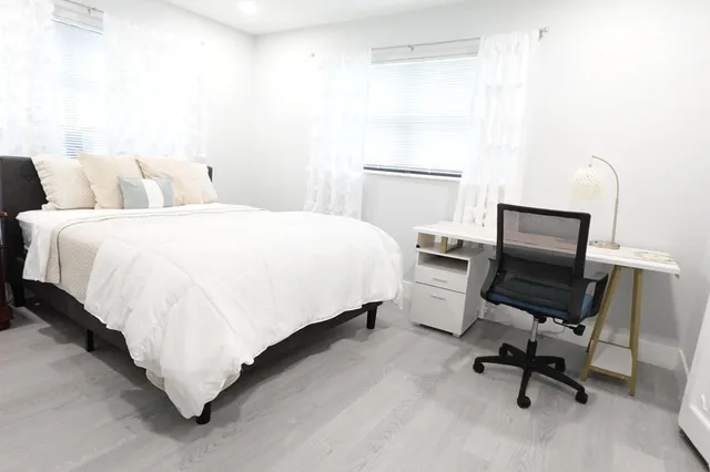 a bedroom with a bed chair and a desk