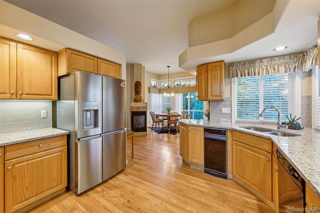 a kitchen with stainless steel appliances granite countertop a refrigerator stove and sink