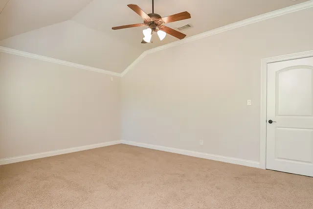 an empty room with chandelier fan and windows