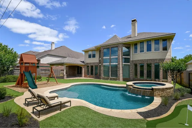 a view of a house with backyard sitting area and pool