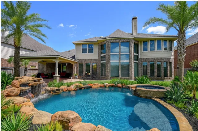 a front view of a house with swimming pool having outdoor seating