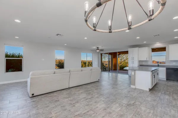 an empty room with ceiling fan and windows