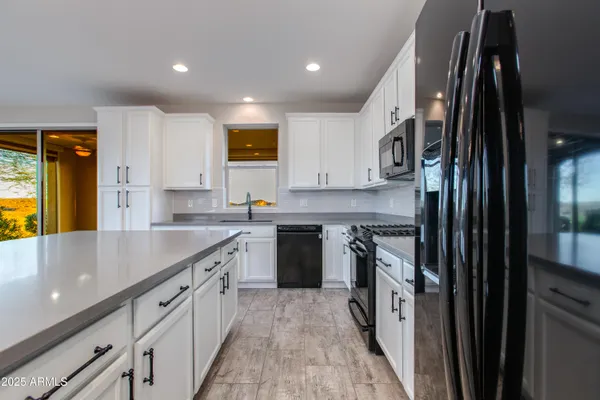 a kitchen with granite countertop white cabinets and white appliances