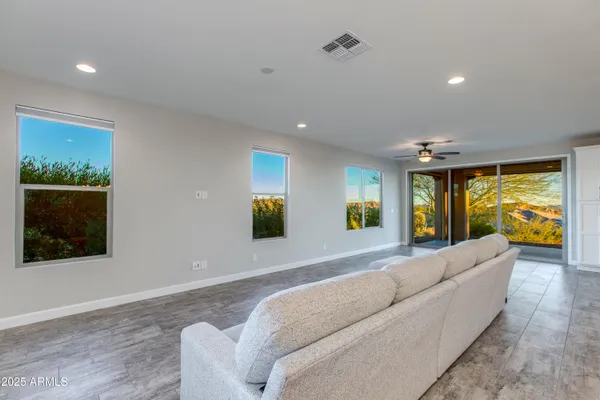 a view of a hallway with a chandelier fan and windows