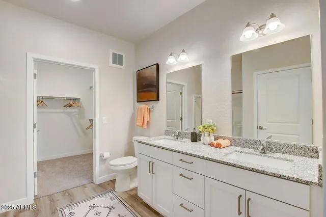 a bathroom with a granite countertop sink a toilet and a mirror