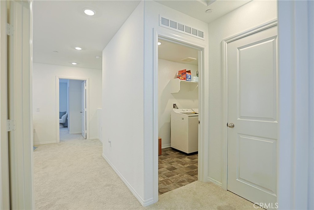 7486 Olive Grv Street Riverside, CA 92507 - Photo 40 of 57 a view of a hallway to a room with wooden floor and a bathroom