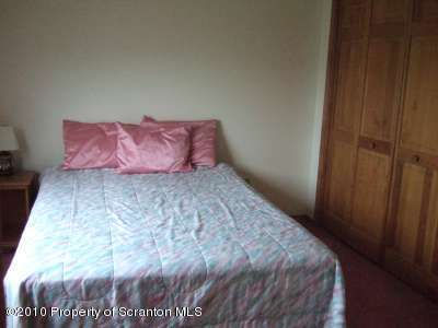2703 Boulder Road Lake Ariel, PA 18436 - Photo 14 of 26 a bed sitting in a bedroom next to a wooden door