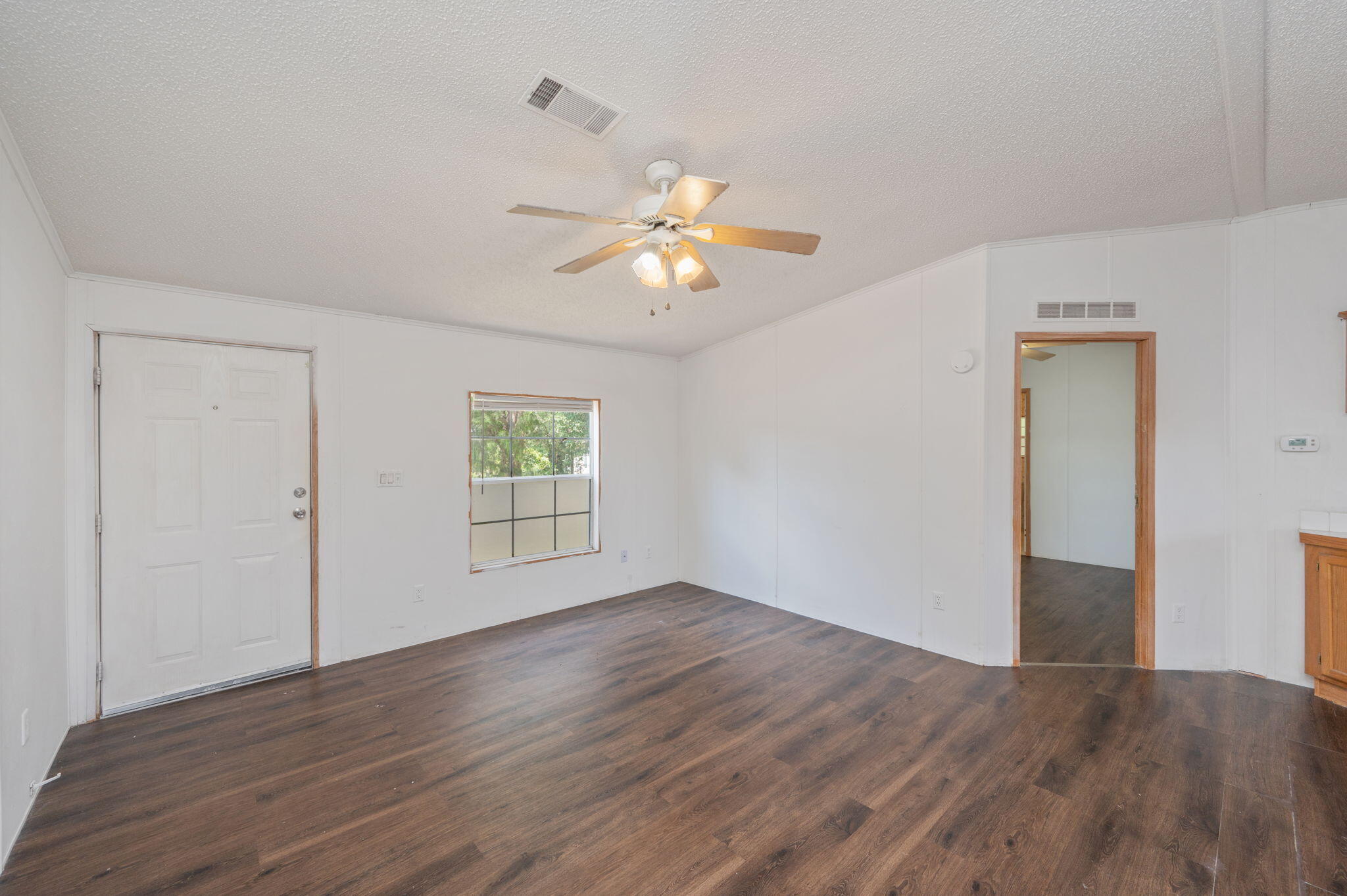 189 Benjamin Street Crestview, FL 32536 - Photo 8 of 40 a view of empty room with wooden floor and fan