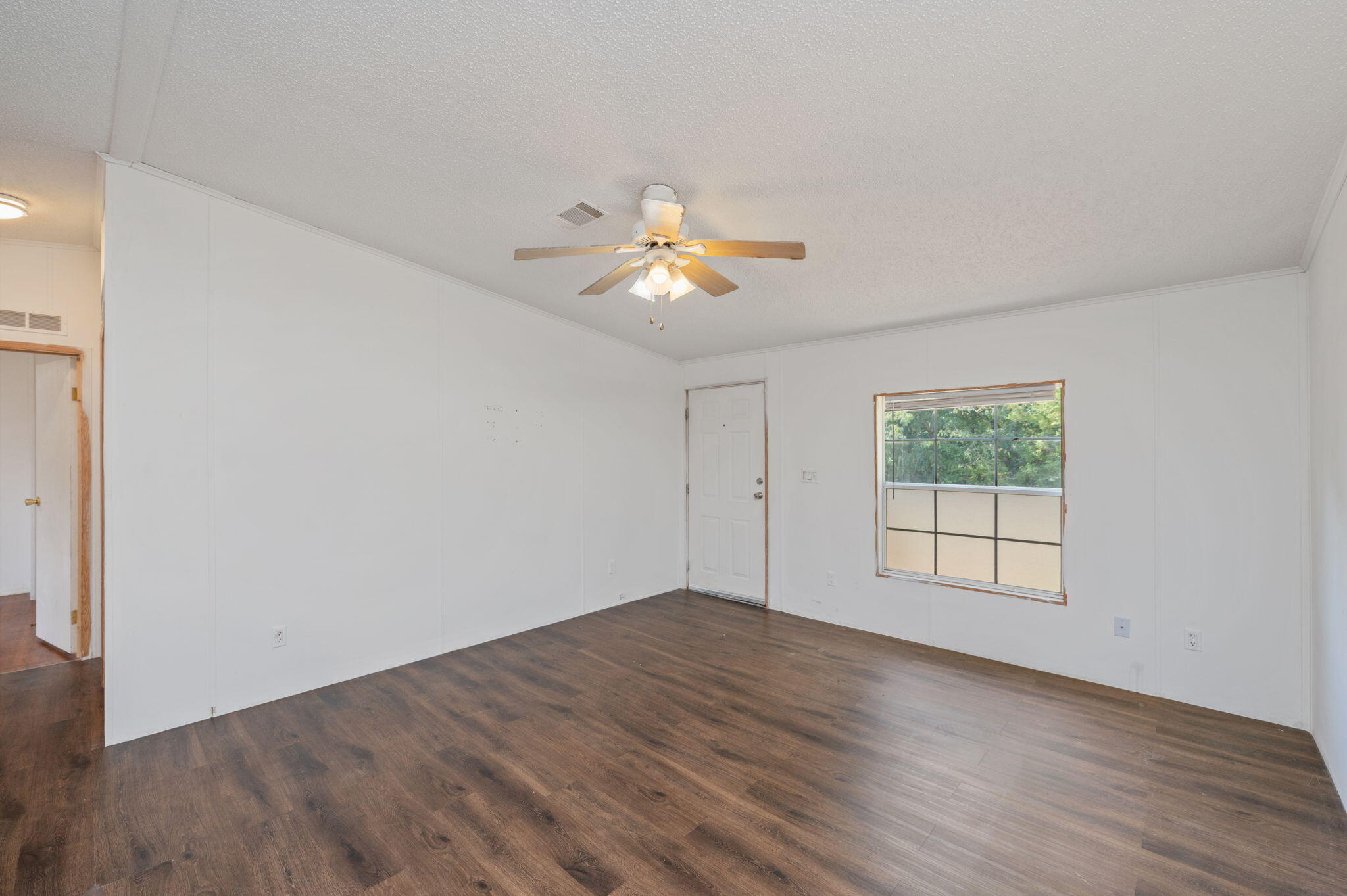 189 Benjamin Street Crestview, FL 32536 - Photo 10 of 40 an empty room with wooden floor and windows