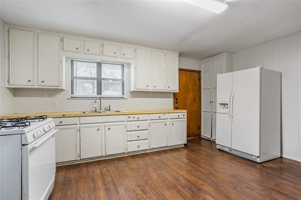 8136 Carlos Street, Unit B White Settlement, TX 76108 - Photo 13 of 17 a kitchen with granite countertop white cabinets and white appliances