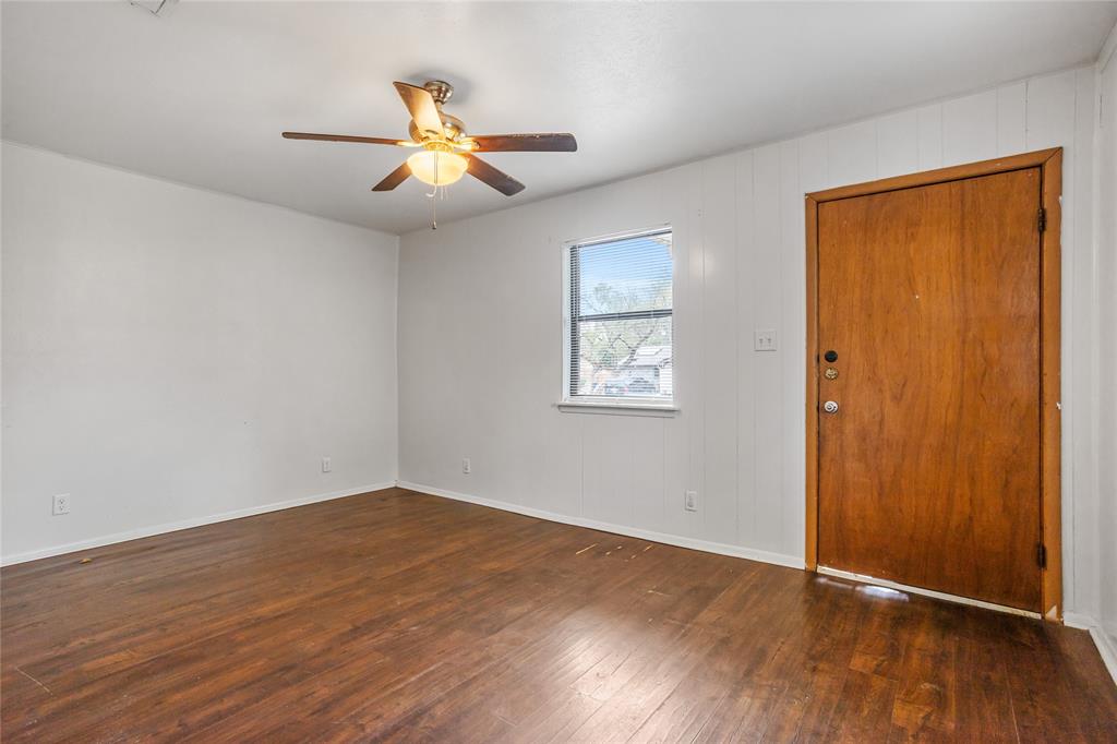 8136 Carlos Street, Unit B White Settlement, TX 76108 - Photo 5 of 17 a view of an empty room with wooden floor and a ceiling fan
