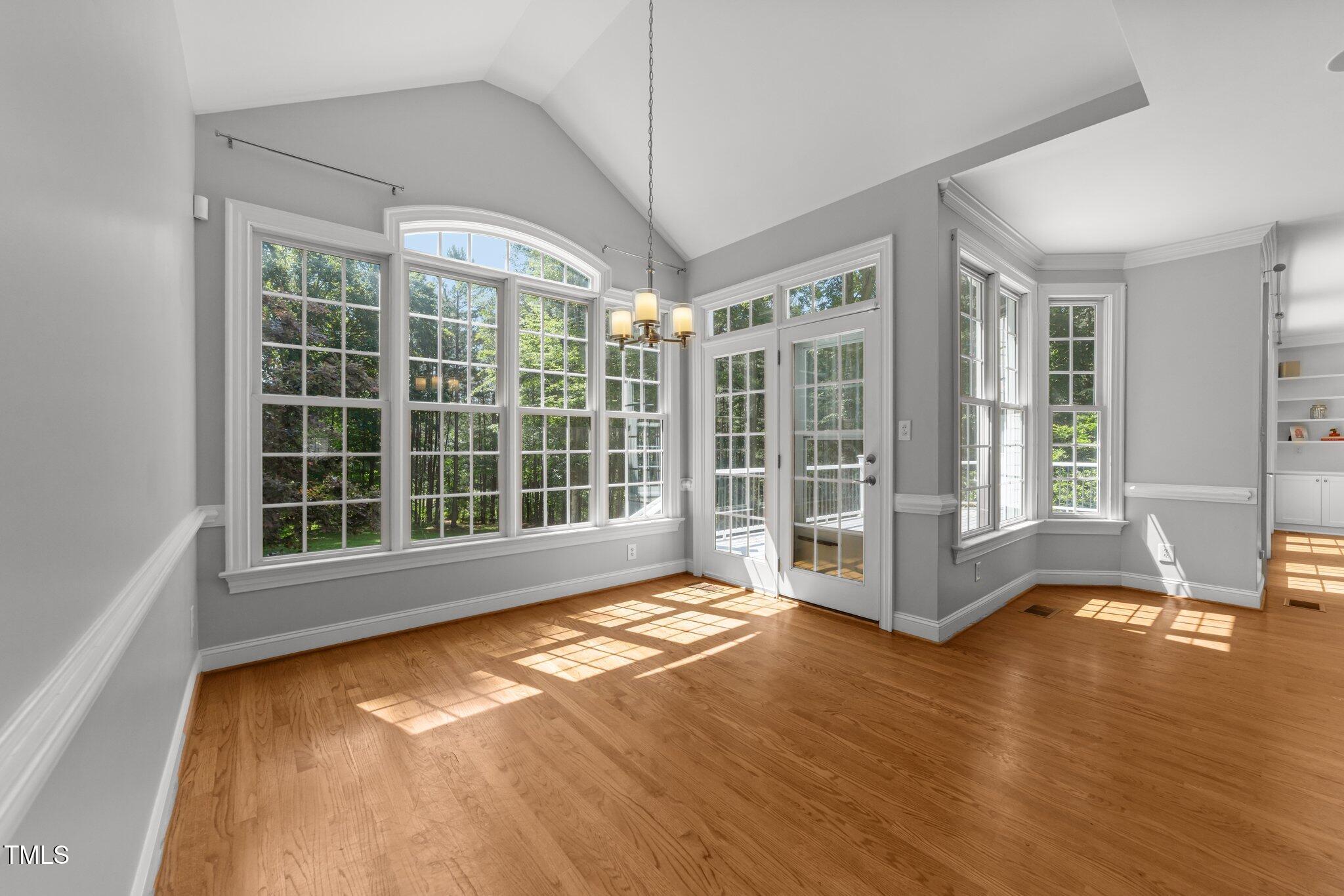 7000 Millstone Ridge Court Raleigh, NC 27614 - Photo 15 of 70 a view of an empty room with wooden floor and a window