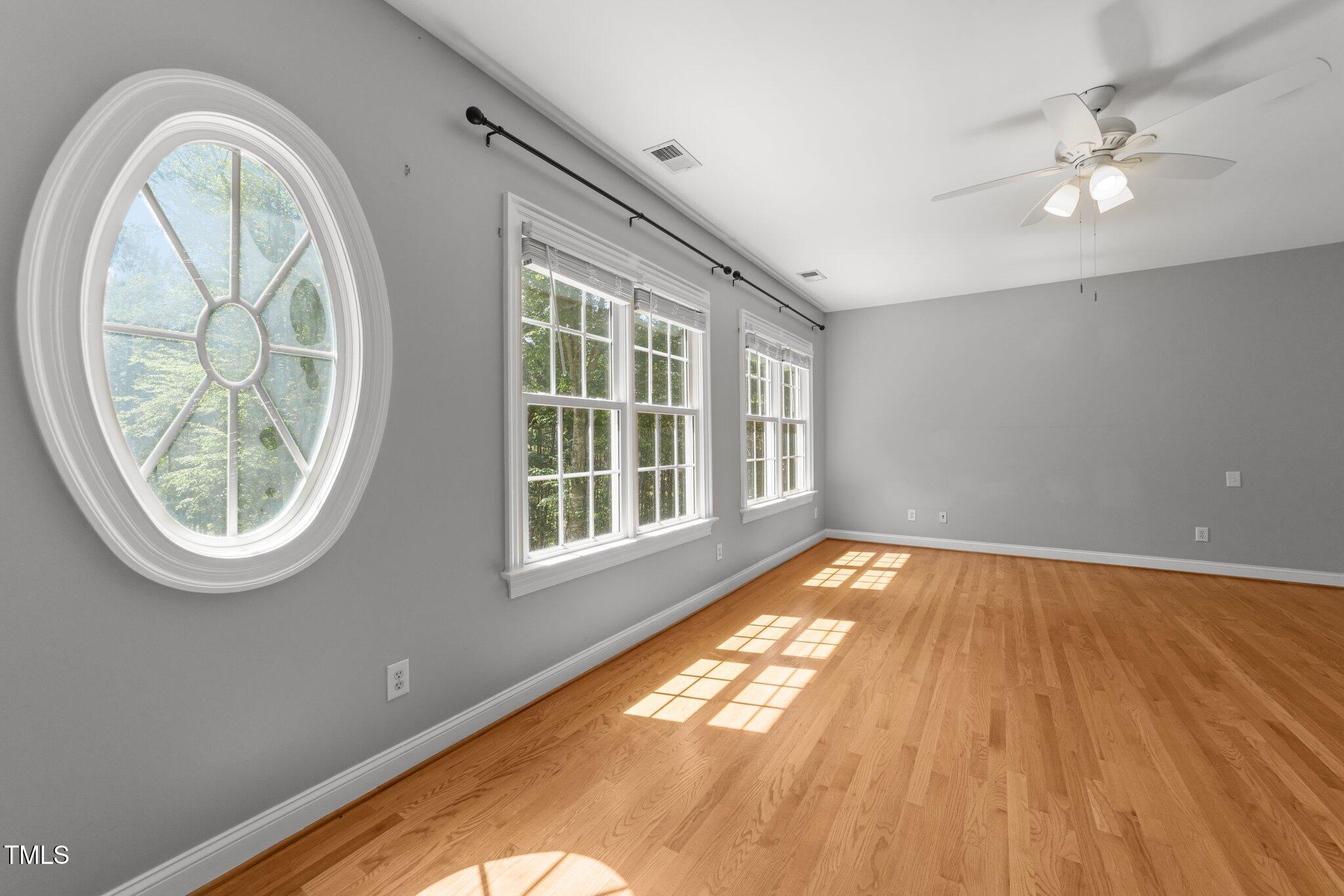 7000 Millstone Ridge Court Raleigh, NC 27614 - Photo 25 of 70 an empty room with wooden floor fan and windows