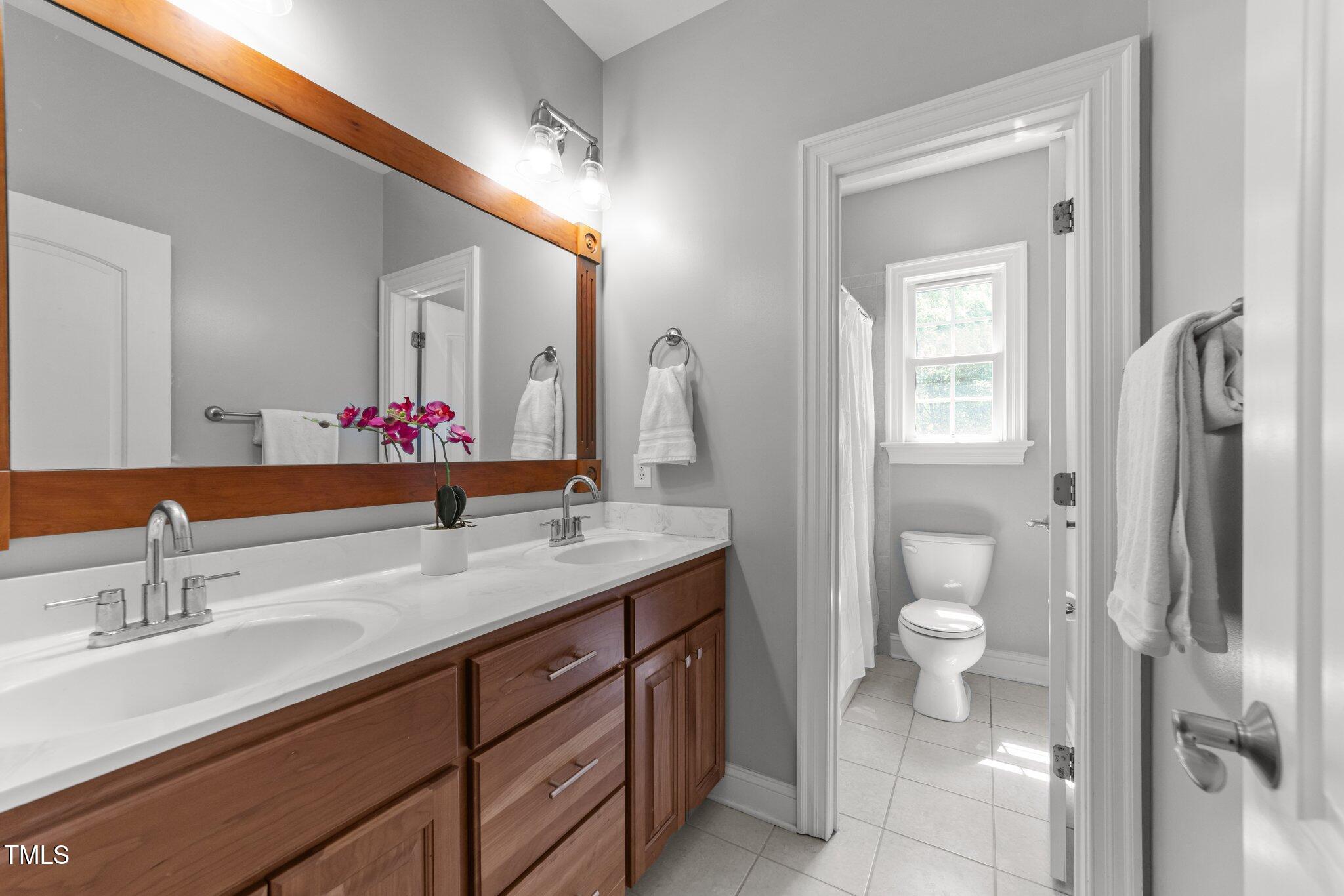 7000 Millstone Ridge Court Raleigh, NC 27614 - Photo 36 of 70 a bathroom with a granite countertop sink toilet and shower