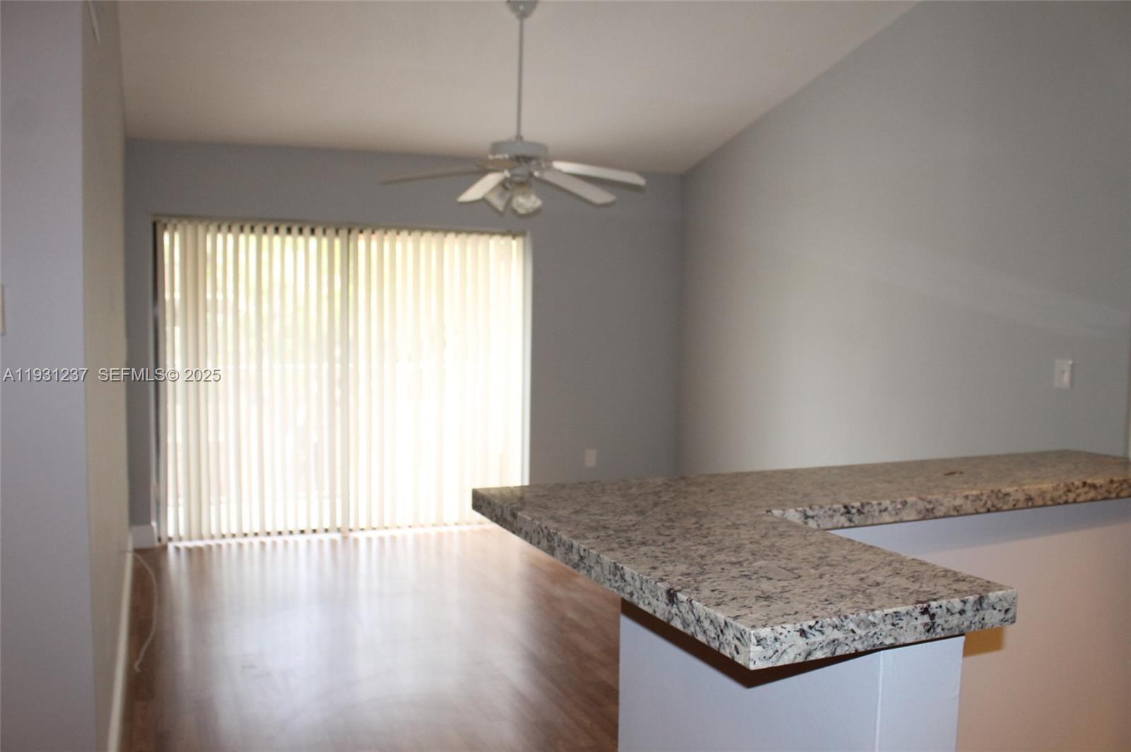 7135 Northwest 179th Street, Unit 302 Hialeah, FL 33015 - Photo 3 of 6 an empty room with wooden floor and windows