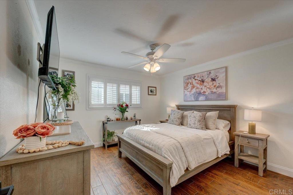 10321 Santana Ranch Drive Santee, CA 92071 - Photo 17 of 28 a bedroom with a large bed and a chandelier