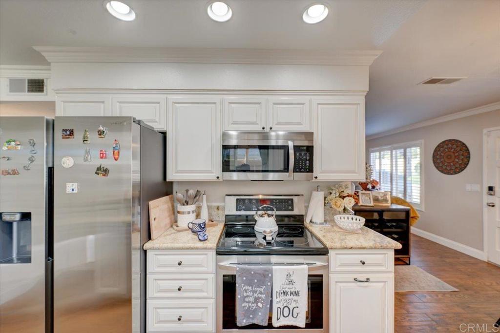 10321 Santana Ranch Drive Santee, CA 92071 - Photo 10 of 28 a kitchen with stainless steel appliances granite countertop a stove a refrigerator and a refrigerator