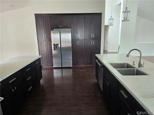 a kitchen with kitchen island granite countertop a sink and refrigerator