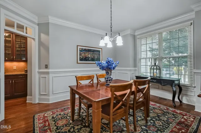 a dining room with furniture a chandelier and wooden floor