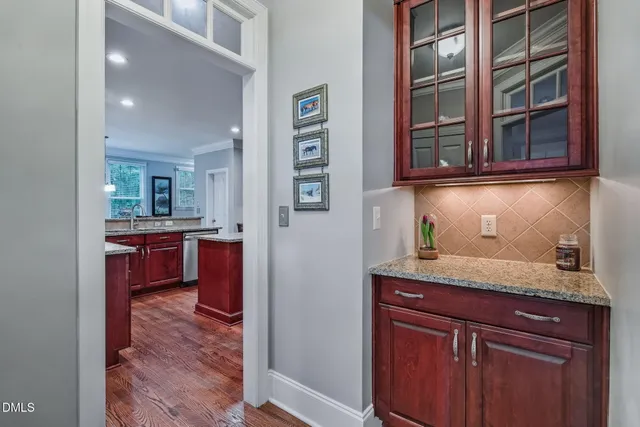 a view of kitchen with granite countertop cabinets and window