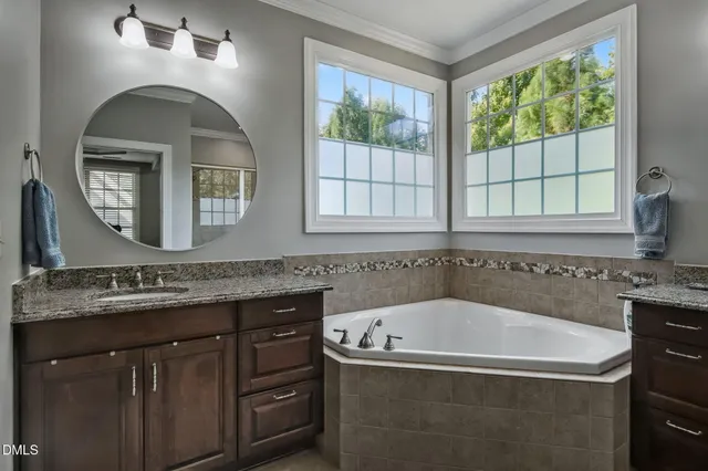 a bathroom with a tub a sink and a window