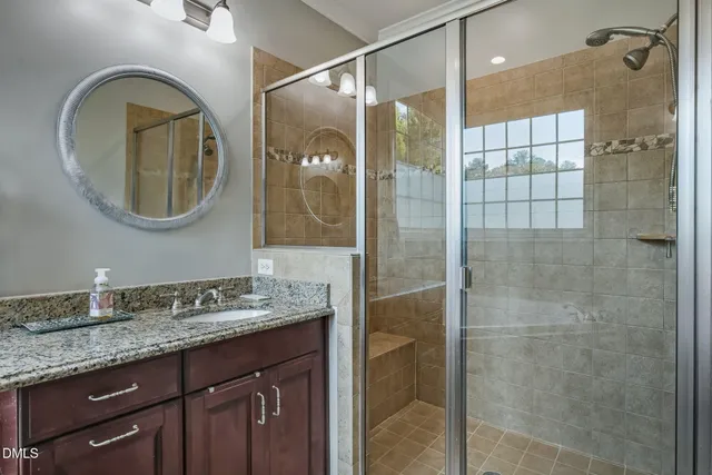 a bathroom with a granite countertop double vanity sink and a mirror