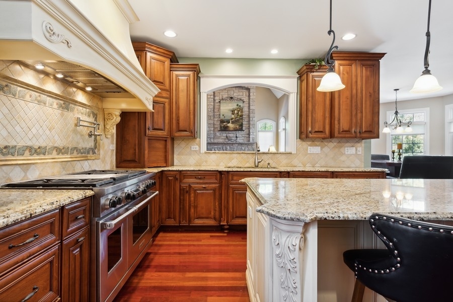 4050 Douglas Road Downers Grove, IL 60515 - Photo 17 of 60 a kitchen with stainless steel appliances granite countertop wooden cabinets and a stove top oven