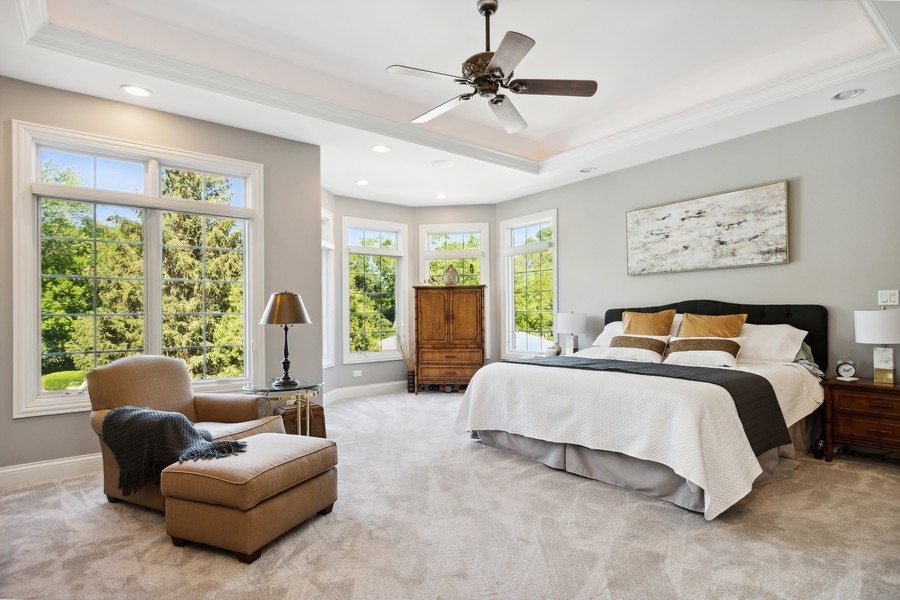 4050 Douglas Road Downers Grove, IL 60515 - Photo 25 of 60 a spacious bedroom with a bed couch and a large window