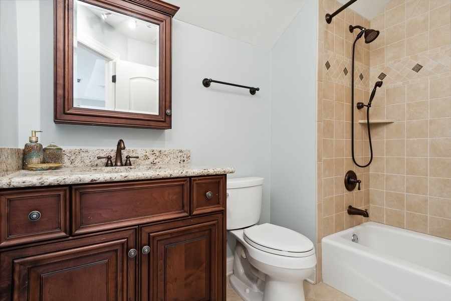 4050 Douglas Road Downers Grove, IL 60515 - Photo 32 of 60 a bathroom with a granite countertop toilet sink and mirror