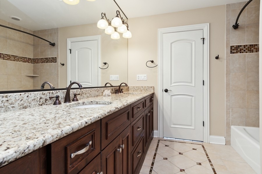 4050 Douglas Road Downers Grove, IL 60515 - Photo 34 of 60 a bathroom with a granite countertop sink and a mirror