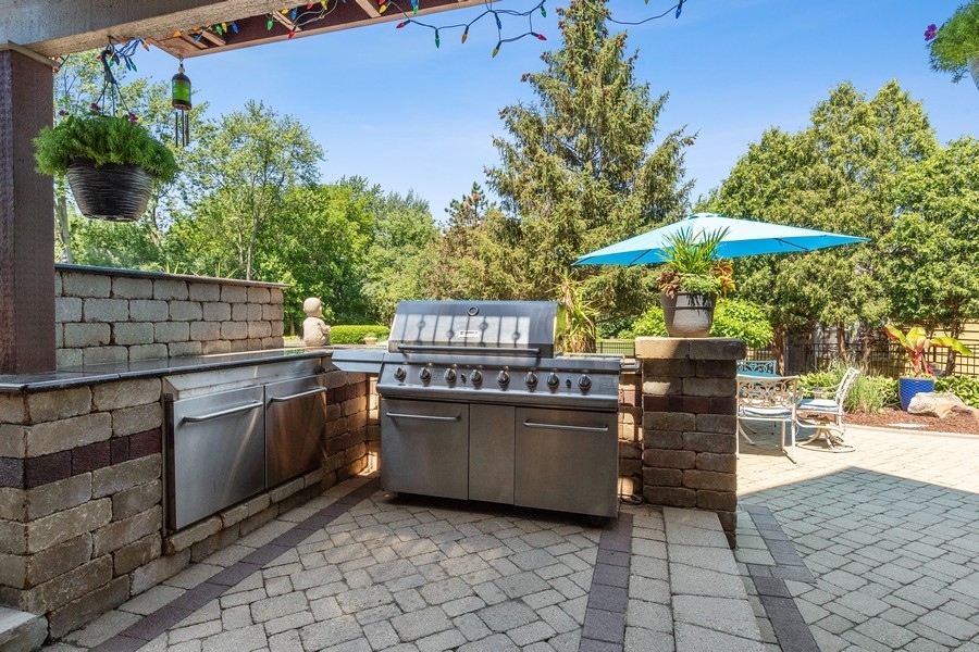 4050 Douglas Road Downers Grove, IL 60515 - Photo 45 of 60 a view of a patio with table and chairs under an umbrella