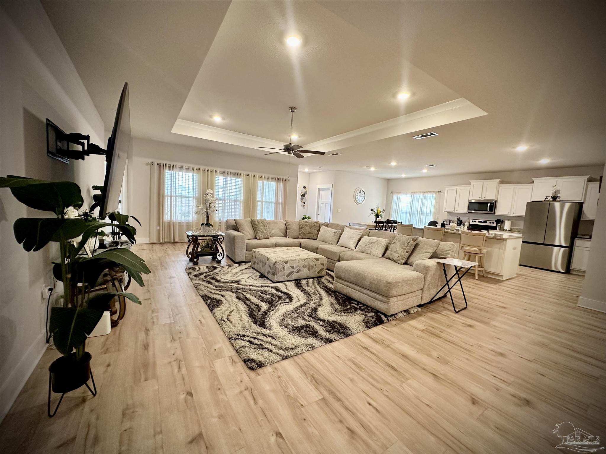 a living room with lots of furniture and a wooden floor
