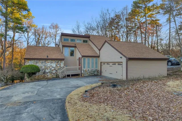 a view of a house with a yard and large tree