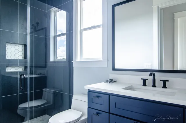 a bathroom with a sink vanity granite toilet and a mirror