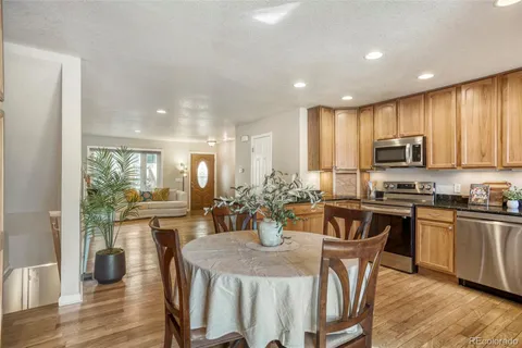 a kitchen with stainless steel appliances granite countertop a stove a refrigerator a kitchen island a table and chairs